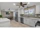 Spacious kitchen with stainless steel appliances, white cabinetry and view of the dining room, with tiled floors at 421 E Terrace Ave, Gilbert, AZ 85234