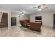 Relaxing living room showcasing tile flooring, a secure safe, and comfortable brown seating arrangement at 421 E Terrace Ave, Gilbert, AZ 85234