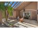 Inviting covered patio with hanging chandelier, seating, desert landscaping and natural light at 421 E Terrace Ave, Gilbert, AZ 85234