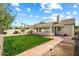 Backyard features green lawn, mature trees, covered patio, tile patio, and perimeter landscaping at 4546 E Villa Rita Dr, Phoenix, AZ 85032