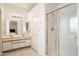 A bathroom featuring dual sinks, a large mirror, and a glass shower at 4546 E Villa Rita Dr, Phoenix, AZ 85032