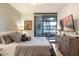 Bedroom with large bed, hardwood floors, dresser and a large glass sliding door to outdoor seating at 4808 N 24Th St # 303, Phoenix, AZ 85016