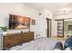 Modern bedroom with wooden dresser, TV, and access to a well lit ensuite bathroom at 4808 N 24Th St # 303, Phoenix, AZ 85016