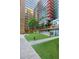 Open-air courtyard with trees, artificial grass, and walking paths at 4808 N 24Th St # 303, Phoenix, AZ 85016