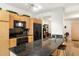 Modern kitchen with wood cabinets, black appliances, and stone countertop with a view into dining at 4808 N 24Th St # 303, Phoenix, AZ 85016