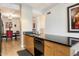 Galley kitchen with wooden cabinetry and black countertops, with a view to the dining room at 4808 N 24Th St # 303, Phoenix, AZ 85016