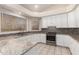 Well-lit kitchen featuring white cabinets, granite countertops, and updated appliances at 4815 E Fernwood Ct, Cave Creek, AZ 85331
