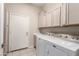 Functional laundry room with tile floors, cabinets, and side-by-side washer and dryer at 4815 E Fernwood Ct, Cave Creek, AZ 85331