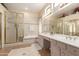 Bright bathroom with a glass-enclosed shower, bathtub, double vanity, and ample counter space at 5811 W Irma Ln, Glendale, AZ 85308