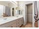 Bathroom with double vanity, tile flooring, neutral colors, and a shower with patterned tiling at 5811 W Irma Ln, Glendale, AZ 85308