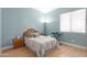 Bright bedroom features calming blue walls, a comfortable bed, and natural light from a window at 5811 W Irma Ln, Glendale, AZ 85308
