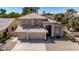 An elevated view of a stucco home featuring a three-car garage and a tile roof at 5811 W Irma Ln, Glendale, AZ 85308