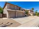 A well-maintained stucco home showcasing a spacious three-car garage and mature landscaping at 5811 W Irma Ln, Glendale, AZ 85308