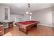 Game room featuring a pool table with a red felt top, hardwood floors, and a wall-mounted cue rack at 5811 W Irma Ln, Glendale, AZ 85308