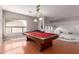 Game room with a red felt pool table, hardwood floors, and a view of the upstairs railing at 5811 W Irma Ln, Glendale, AZ 85308