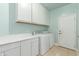 Well-lit laundry room with white cabinets, countertops, and a modern washer and dryer at 5811 W Irma Ln, Glendale, AZ 85308