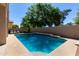 Backyard pool with a textured concrete patio and a decorative raised wall with mosaic tile at 5811 W Irma Ln, Glendale, AZ 85308
