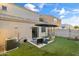 Backyard with artificial turf and outdoor seating area with sun umbrella at 7010 W Downspell Dr, Peoria, AZ 85345