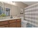Bathroom features a wood vanity with framed mirror and neutral decor at 7010 W Downspell Dr, Peoria, AZ 85345