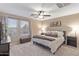 Comfortable bedroom with a ceiling fan, window and king size bed at 7010 W Downspell Dr, Peoria, AZ 85345