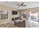 Comfortable living room featuring a large sectional sofa, ceiling fan, and natural light at 7010 W Downspell Dr, Peoria, AZ 85345