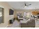 Comfortable living room featuring a large sectional sofa, ceiling fan, and natural light at 7010 W Downspell Dr, Peoria, AZ 85345