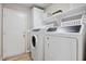 Functional laundry room with a white washer and dryer, white cabinets, and a wood-look floor at 721 W Mountain Sky Ave, Phoenix, AZ 85045