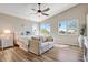 Bright main bedroom with wood floors, a ceiling fan, two windows, and a cozy loveseat at 721 W Mountain Sky Ave, Phoenix, AZ 85045