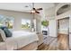 Bright main bedroom boasts wood floors, a ceiling fan, two windows, and a fireplace with a TV above it at 721 W Mountain Sky Ave, Phoenix, AZ 85045