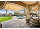 Relaxing patio area with a pool, fire pit, built-in grill, and manicured putting green at 721 W Mountain Sky Ave, Phoenix, AZ 85045