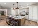 Modern kitchen features white cabinets, marble backsplash, and a wooden island with bar seating and statement pendant lighting at 7520 E Valley View Rd, Scottsdale, AZ 85250