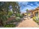 A brick patio with an overhead pergola that looks out to a landscaped yard with a black metal fence at 7807 E Granada Rd, Scottsdale, AZ 85257