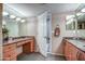 Bathroom with double vanities and granite countertops; large mirrors and wood cabinets at 7807 E Granada Rd, Scottsdale, AZ 85257