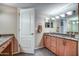 Bathroom with double vanity sinks, granite countertops, and wood cabinets at 7807 E Granada Rd, Scottsdale, AZ 85257