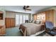 Cozy bedroom featuring a ceiling fan, shuttered window, and built in closet and display shelving at 7807 E Granada Rd, Scottsdale, AZ 85257