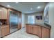 Bright kitchen featuring stainless steel refrigerator, wooden cabinets, granite counters and tile floors at 7807 E Granada Rd, Scottsdale, AZ 85257
