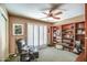 This room features a ceiling fan, a comfortable black armchair, and large windows with white shutters at 7807 E Granada Rd, Scottsdale, AZ 85257
