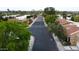 Aerial view down tree-lined community street with manicured landscaping and picturesque mountain views at 7807 E Granada Rd, Scottsdale, AZ 85257