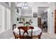 Dining area featuring tiled floors, bright lighting, and view to living room at 8402 W Laurel Ln, Peoria, AZ 85345