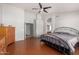 Large main bedroom featuring wood floors, ceiling fan, and ensuite bathroom with a walk-in closet at 8402 W Laurel Ln, Peoria, AZ 85345
