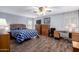 Bedroom with wood floors, bed with blue patterned comforter and a ceiling fan at 9333 E University Dr # 113, Mesa, AZ 85207
