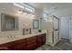 Modern bathroom with double vanity, framed mirrors, and glass-enclosed shower at 9442 N 118Th St, Scottsdale, AZ 85259