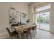 Bright and airy dining room featuring a wooden table, modern chairs, and glass doors leading to the pool at 9442 N 118Th St, Scottsdale, AZ 85259