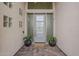 Modern front entrance with a stylish door, decorative plants, and a welcoming doormat on a brick-paved porch at 9442 N 118Th St, Scottsdale, AZ 85259