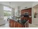 Modern kitchen with a large island, dark wood cabinets, and views of the backyard at 9442 N 118Th St, Scottsdale, AZ 85259