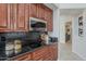 Close-up of kitchen showing black granite counters, stainless steel microwave, and dark wood cabinets at 9442 N 118Th St, Scottsdale, AZ 85259
