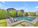 Lounge by the pool in this backyard oasis featuring artificial turf and mature landscaping at 9942 E Rotation Dr, Mesa, AZ 85212