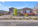 Beautiful two-story home featuring manicured landscaping and a charming stone facade at 9942 E Rotation Dr, Mesa, AZ 85212