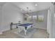 Entertaining game room includes a pool table, stylish lighting, and lots of natural light from three windows at 9942 E Rotation Dr, Mesa, AZ 85212