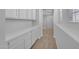 The carpeted hallway provides custom cabinets and shelving with nearby staircase at 9942 E Rotation Dr, Mesa, AZ 85212